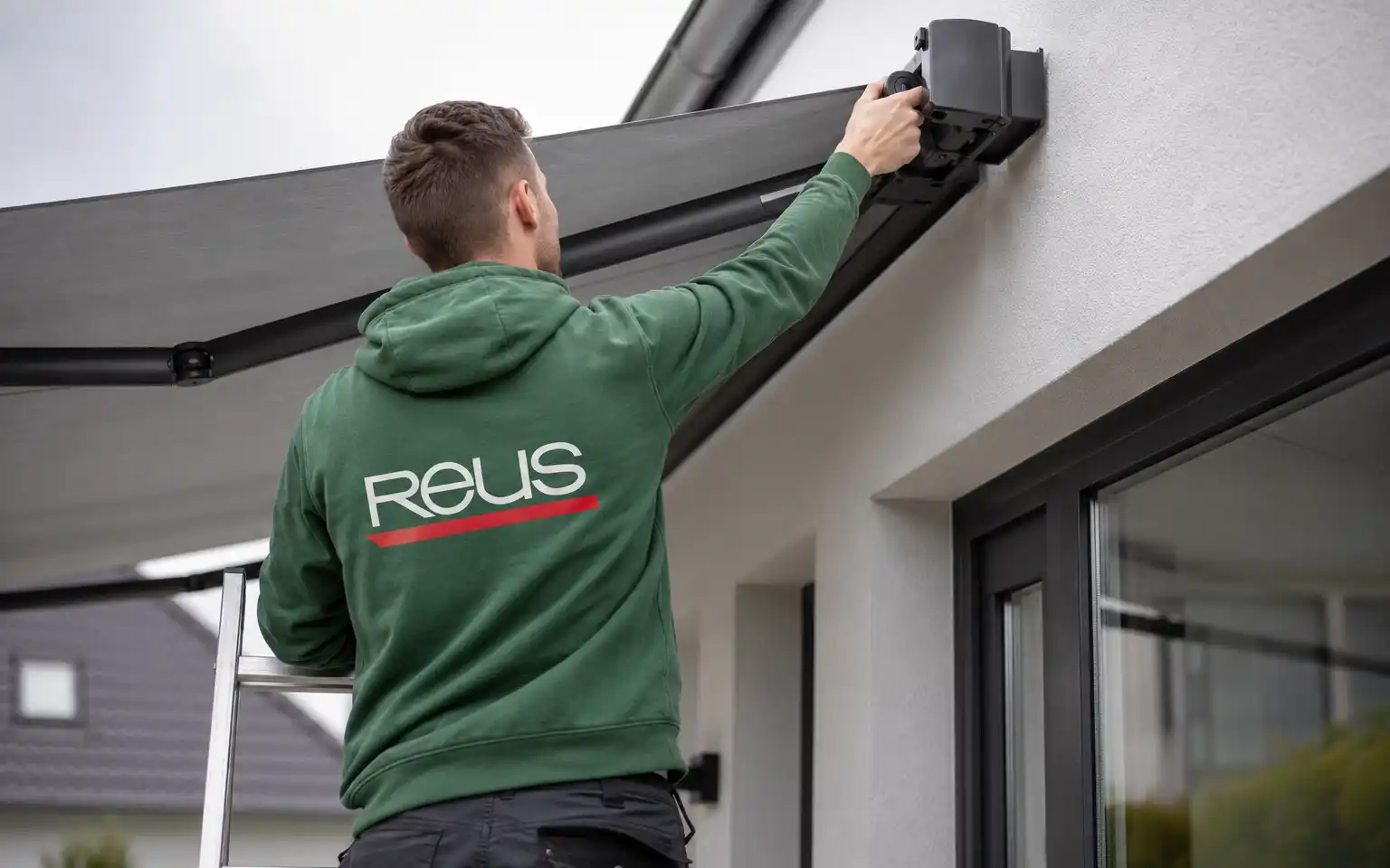 Reus Mitarbeiter montiert Gelenkarmmarkise