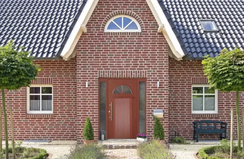 Holzhaustür von Aldra mit gläsernen Inlays an modernem Backsteinhaus in norddeutschem Stil